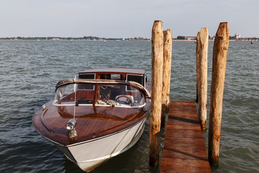 Motorboat docked near the wooden poles in Venice.