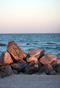 Pile of rocks by the sea on a summer evening