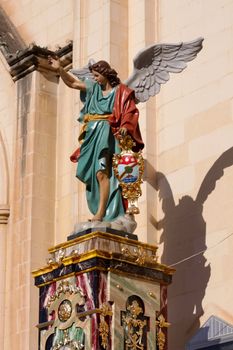 A statue of an angel outside a Maltese church
