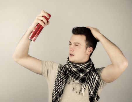 Young man spray with hairspray