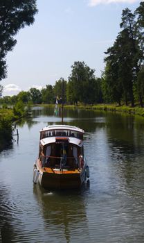 An old wooden boat travelling on Gota Canal on a beautiful sunny day