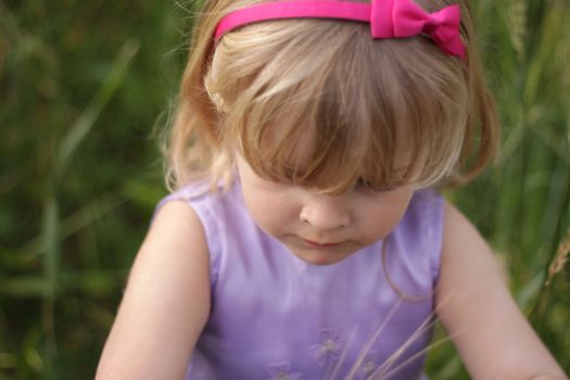 3 year old girl with blond hair and a bright pink hairband