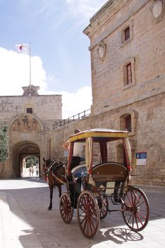 A horse cart used to drive around tourists in the old capital of Malta is waiting by the city gate
