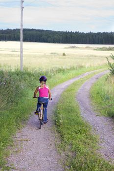 Childe riding a bicycle in the country side