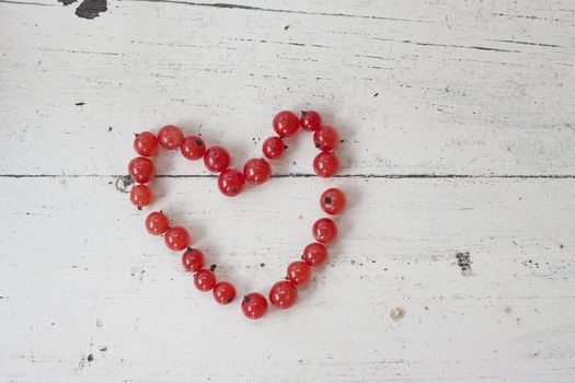 A string of red currants form the shape of a heart
