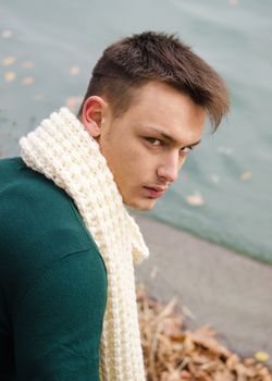 Attractive young man with scarf outdoors in nature (river, lake)