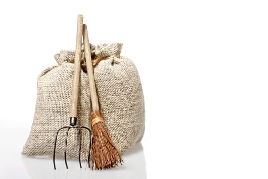 Bags with potatoes and agricultural tools on a white background