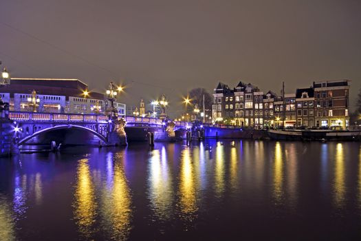 Amsterdam by night with the Blue Bridge at the Amstel in the Netherlands