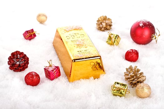 Golden bar as christmas present in the snow with ornaments