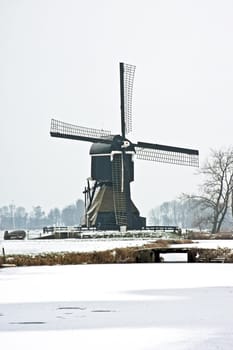 Snowy traditional windmill in the countryside from the Netherlands