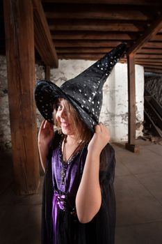 Cute little girl holding witch hat and smiling