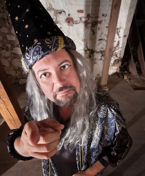 Middle aged serious European male wizard pointing