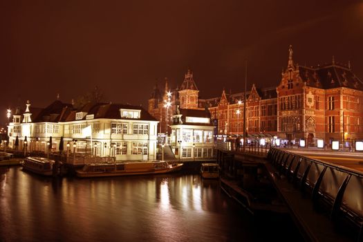 City scenic from Amsterdam with the central station at night in the Netherlands