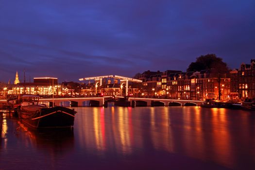 City scenic from Amsterdam with the Thiny bridge at night in the Netherlands