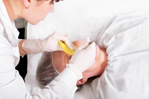 Woman making recreational skin treatment in the spa salon.