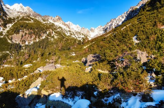 Winter mountains and shadow silhouette of a standing man