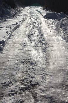 very frozen mountain road, lit by sunlight