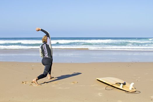 Young guy doing exercises before going to surf