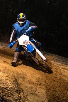 Enduro bike rider on action. Turn on sand terrain.