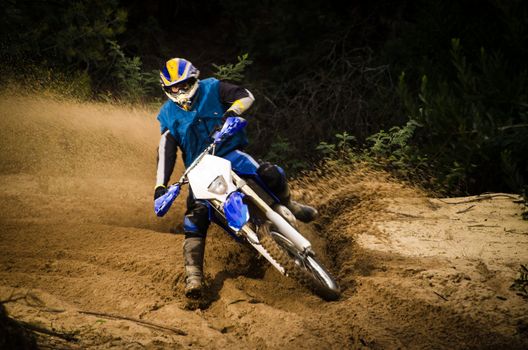 Enduro bike rider on action. Turn on sand terrain.