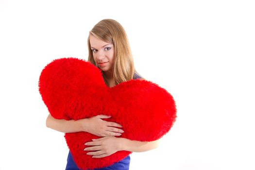 Young beautiful  girl  hugs a big soft heart. Feast of St. Valentine's Day.