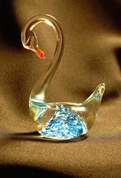 Figurine glass swan with a bright blue pattern on a black background