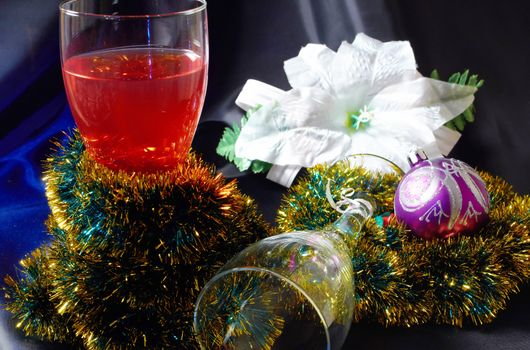 Wineglass and white artificial flower decorated lights and Christmas ball on a black background