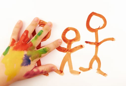 Child's hand covered in paint drawing funny little people