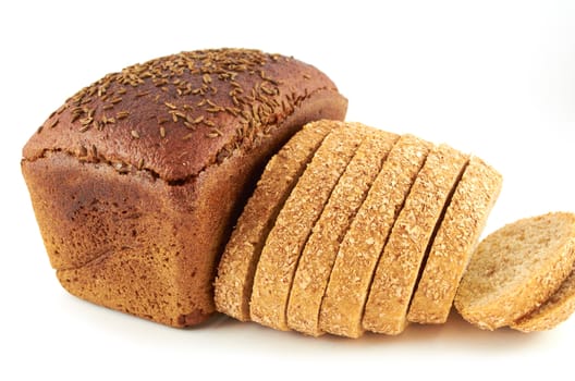 A loaf of rye bread topped with coriander seeds and sliced wheat ​​bread with bran