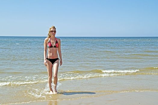 Young blonde woman coming out of the water from the ocean