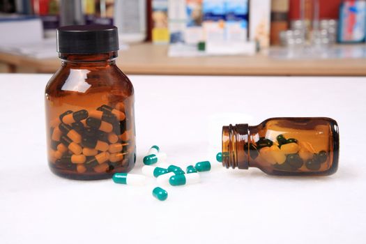 medicine pills pouring out of orange bottle on a white marble. selective focus