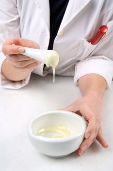 hands mixing ingredients on mortar to make cream