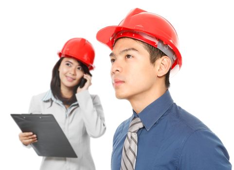 A man and a womanl wearing hardhats and looking up (on white)