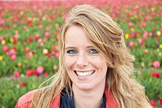 Beautiful happy woman in the tulip fields in the Netherlands