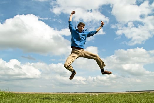 Happy guy jumping in the air on a beautiful day in springtime