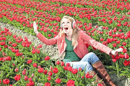 Happy girl enjoying the music in the tulip fields from the Netherlands