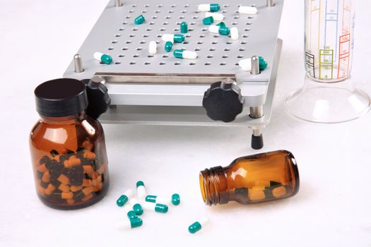 medicine pills pouring out of orange bottle on a white marble. selective focus