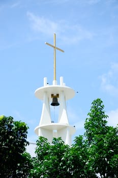 Cross on top of bell tower with sky background