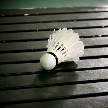 Shuttle cock on wooden table in the badminton court