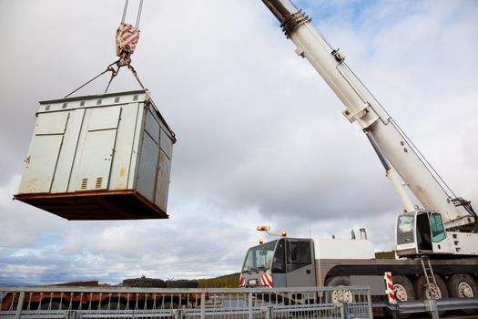 Mobile crane makes emergency operation on a motorway. Move container cargo.