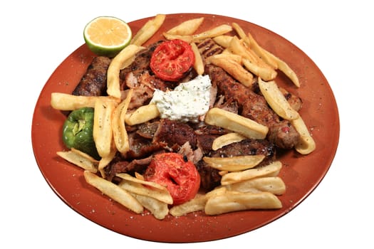 kebab served on plate  with fries tomato and tzatziki