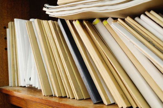 Wooden shelf with file folders, archival documents.