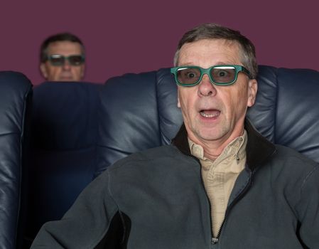 Senior male with shocked expression watching movie in home theater in 3d glasses