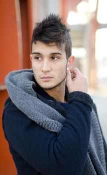 Handsome young man in urban or industrial environment, winter clothes