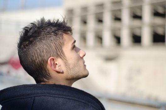 Attractive young man looking up, profile shot