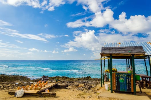 Outdoor bar with drinks in coconuts and souvenirs for sale in San Andres, Colombia