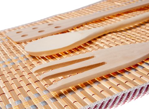 set of three wooden kitchenware on bamboo napkin