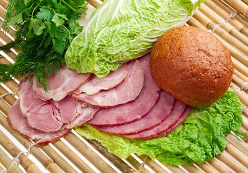 Beautiful sliced food arrangement of meat, bread and vegetables . bamboo napkin