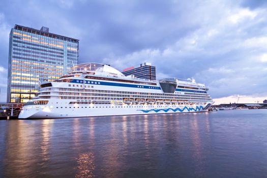 Cruise boat in Amsterdam harbor in the Netherlands at twilight