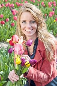 Beautiful woman with tulips in the tulip fields in the Netherlands